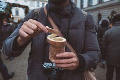 a man holding an ice cream cone in his hand and taking a photo with a camera