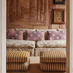 a living room filled with lots of furniture next to a wall covered in wood paneling