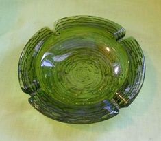 a green glass bowl sitting on top of a table