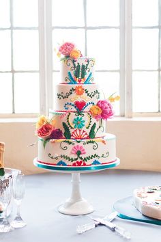 a colorful wedding cake sitting on top of a table next to a window with the words, i'm helping plan of my best friend's bridal showerers and wow