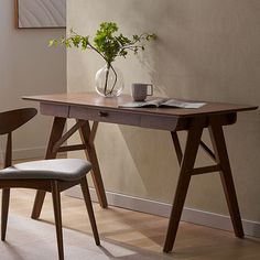 a table with two chairs and a vase on it next to a wall that has a plant in it