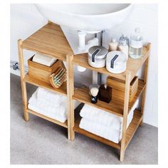 a bathroom sink and shelf with towels on it
