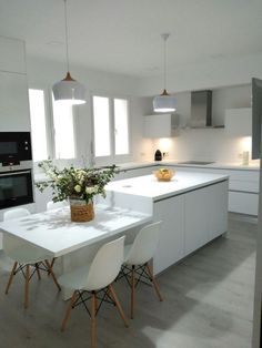 a white kitchen with an island table and chairs