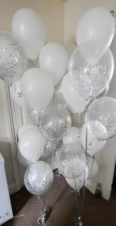 a bunch of white balloons are on the floor in front of a mirror and door