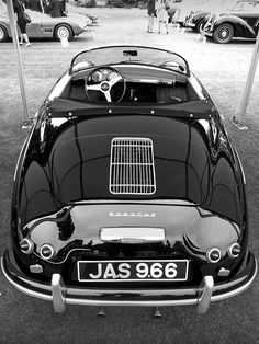 a black and white photo of an old car with the hood up on it's grill