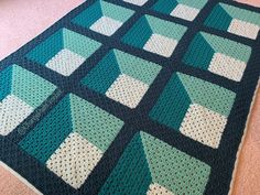 a crocheted blanket is on the floor