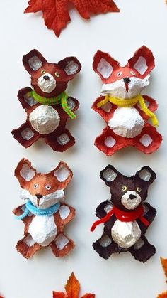 four different colored teddy bears made out of clay and paper machs with autumn leaves in the background