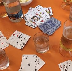 playing cards and drinking glasses on an orange table