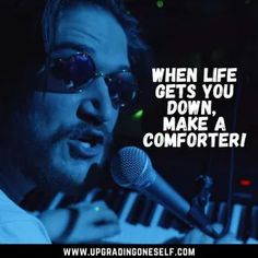 a man singing into a microphone while holding a keyboard in front of him with the words when life gets you down, make a comporter