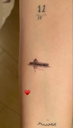 a woman's arm with a tattoo on it and a red heart in the middle