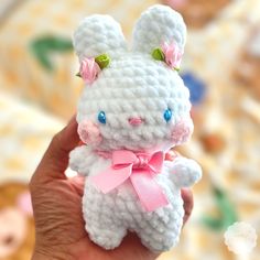 a small crocheted white bunny with pink bows