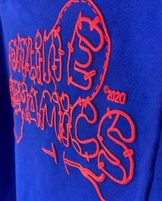 a blue shirt with red writing on it