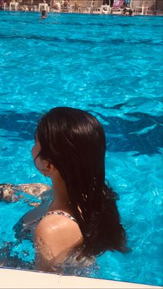 a woman in a swimming pool with a frisbee on her shoulder and head
