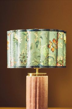 a lamp that is sitting on top of a table next to a vase with flowers