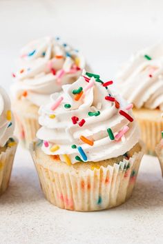 several cupcakes with white frosting and sprinkles