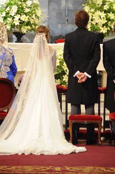 the bride and groom stand at the alter during their wedding ceremony in front of an audience