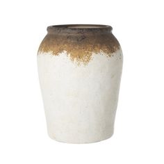 a white and brown vase sitting on top of a table