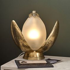 an egg shaped lamp sitting on top of a white table next to a card holder