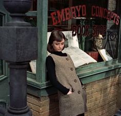 a woman standing in front of a book shop