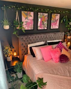 a bedroom decorated in pink and grey with plants on the headboard, bedding, and pillows