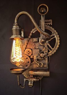 an old fashioned wall lamp with a light bulb and gears attached to the back of it