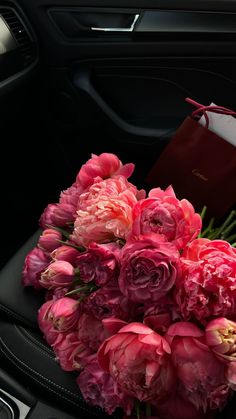 a bouquet of pink flowers sitting on top of a car seat