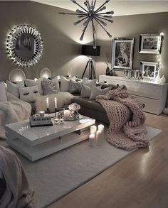 a living room filled with lots of furniture and candles on top of a coffee table