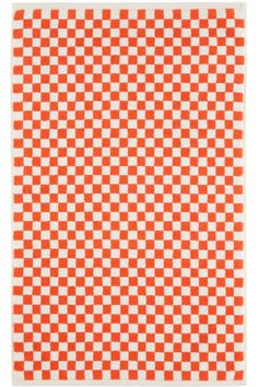 an orange and white checkerboard rug on a white background with the pattern in squares