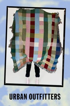 an advertisement for the urban outfitters, featuring a woman standing under a plaid blanket