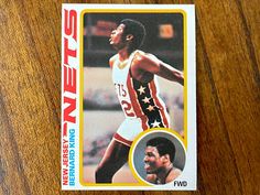 a basketball card with an image of a man in the middle of it on a wooden surface