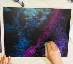 a person is painting on a piece of paper