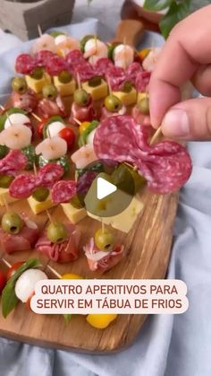 a person holding a skewer of meat and vegetables on a cutting board with the words, quatro appetidos para servir em tabua de frios