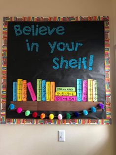 a bulletin board with books on it that says believe in your shelf and pom poms