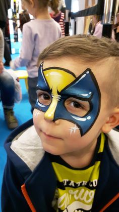 a young boy with his face painted like a fish