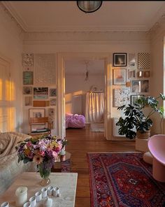 a living room filled with lots of furniture and flowers on top of a coffee table