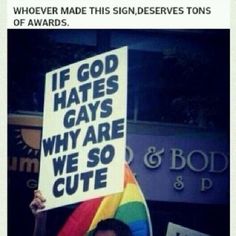 a person holding a sign that says if god hates gays why are we so cute?