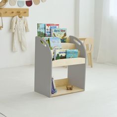 a book stand in the middle of a room with books on it and toys hanging from the wall