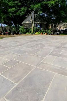 an empty concrete patio with trees in the background