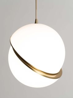 a white and gold light hanging from a ceiling fixture with a circular shape in the center