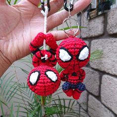 two crocheted spiderman keychains hanging from a string