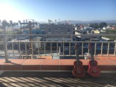 two ukulele sit on a balcony overlooking a city