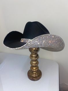 Our black and crystal hat features our square black hat+ crystal rhinestones on the underneath brim. This can easily go with any outfit and can be worn all year long. This hat features: Black square straw hat Crystal rhinestones on the underneath brim Matching crystal hat band Sizing: Our black hats have both sizes S/M and L/XL that features a stretchy hat band We recommend choosing a size S/M if you wear a size 7 1/8 or smaller (which is equivalent to 22 ¼ inches diameter around your head where Bichota Outfit Ideas, Black Glitter Cowboy Hat, Homecoming Cowboy Hats, Decorated Cowboy Hats Diy, Fluffy Cowgirl Hat, Crystal Hat, Cowgirl Hats Western, Two Piece Evening Dresses, Custom Cowboy Hats