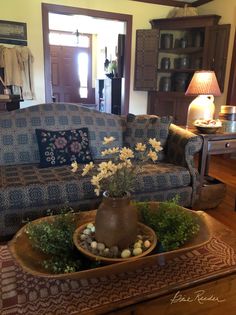 a living room filled with furniture and flowers on top of a table in front of a couch