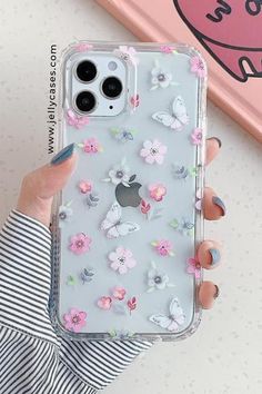 a woman holding an iphone case with flowers on it