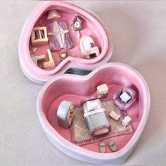 two pink heart shaped boxes filled with miniature furniture