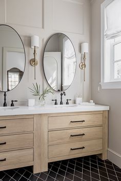 a bathroom with two sinks and three mirrors