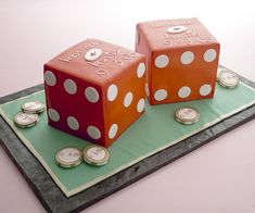 two cakes made to look like dices on top of each other with coins around them