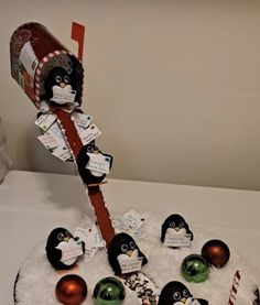 a cake decorated with penguins and candy canes on top of a white tablecloth