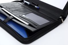 an open laptop case sitting on top of a white table next to a pen and notebook