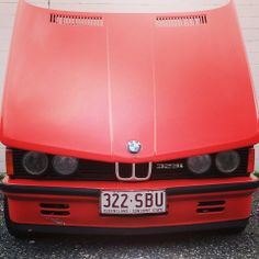 the front end of a red bmw car